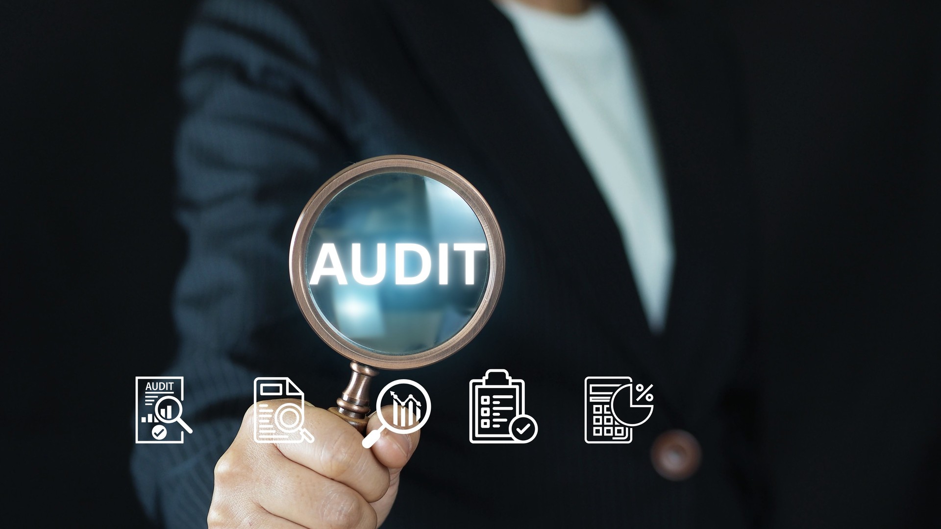 Businessman performing financial audit with magnifying glass on digital dashboard using virtual interface, showcasing data analysis, compliance, and corporate risk management.